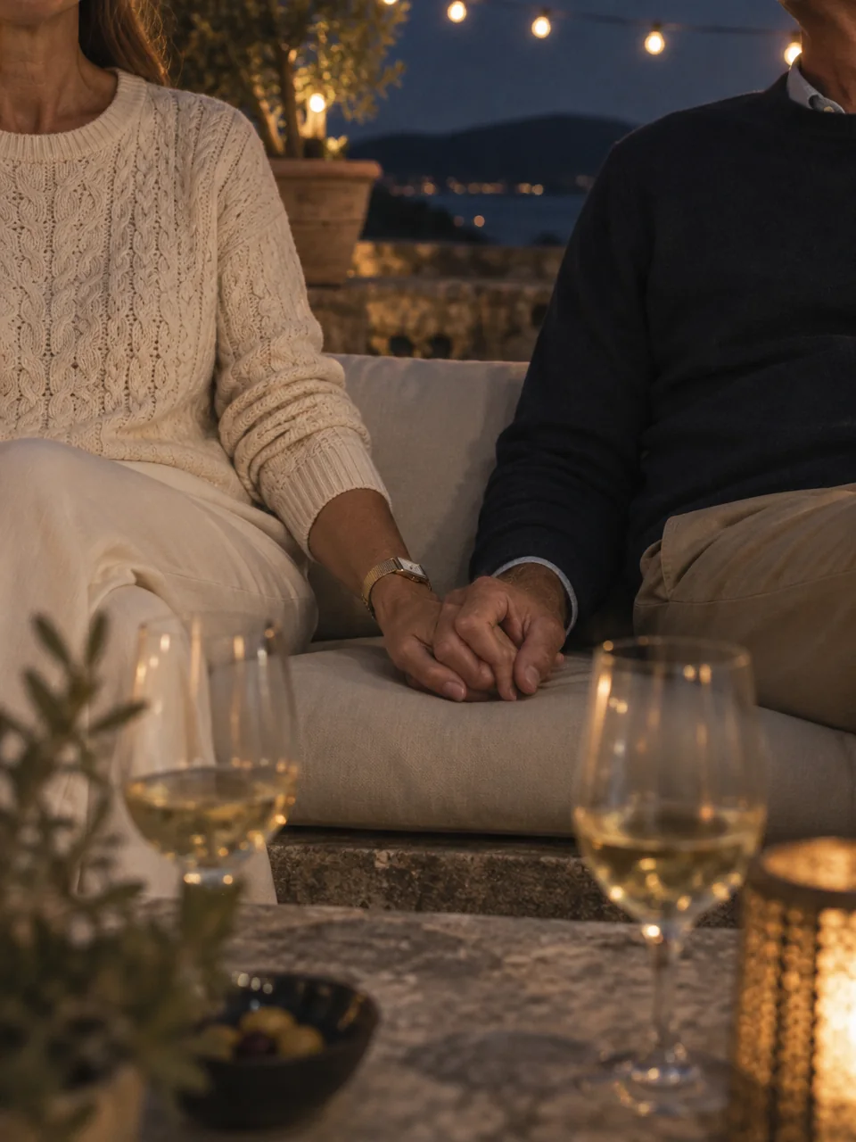 Couple holding hands on a terrace at dusk